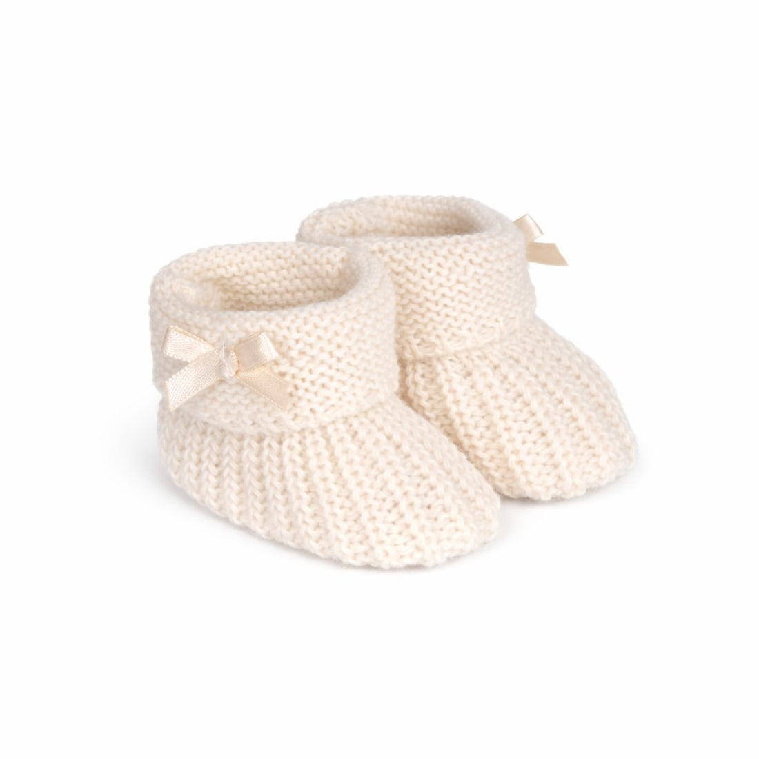 Pair of cream-colored knitted baby booties with ribbons on a white background