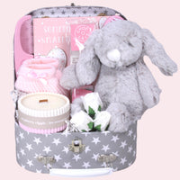 Luxury baby girl newborn hamper with bunny toy, cosy booties and keepsake suitcase.